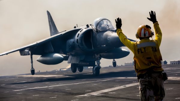 A flight deck crewman directs the pilot of a U.S. Marine Corp AV-8B Harrier as it touches down on the flight deck of the USS Kearsarge (LHD 3) during flight operations at sea on Sept. 24, 2013. The Harrier is assigned to Marine Medium Tiltrotor Squadron 266 (Reinforced) and is embarked on board the Kearsarge as part of the 26th Marine Expeditionary Unit. (DoD photo by Sgt. Christopher Q. Stone, U.S. Marine Corps. (Released))