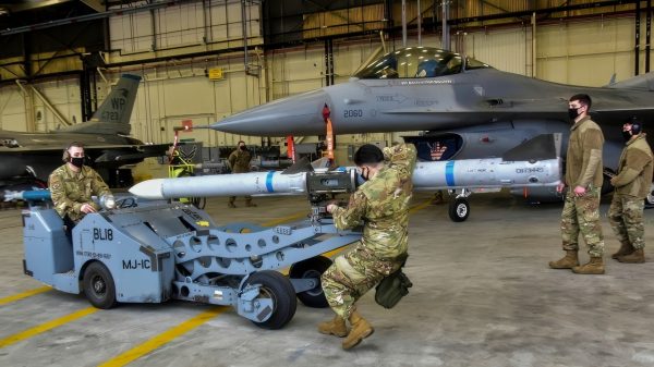Airmen from the 35th Aircraft Maintenance Unit weapons load crew, transport an AIM 9 L/M Sidewinder with an MJ-1 bomb lift truck during the Annual Load Crew Competition at Kunsan Air Base, Republic of Korea, Feb. 6, 2021. Weapons load crews from the 35th Aircraft Maintenance Unit, 80th AMU and 8th Maintenance Squadron were evaluated on how quickly and effectively they could load munitions onto F-16 Fighting Falcons. (U.S. Air Force photo by Tech. Sgt. Kristin High)