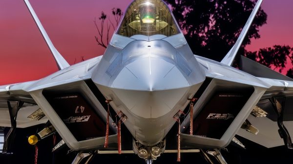 A U.S. Air Force F-22 Raptor assigned to the 199th Air Expeditionary Squadron sits beneath a hangar as the sun sets in Northern Territory, Australia, July 16, 2025, during Talisman Sabre 2025. Talisman Sabre is the largest bilateral military exercise between Australia and the United States advancing a free and open Indo-Pacific by strengthening relationships and interoperability among key allies and partners, while enhancing our collective capabilities to respond to a wide array of potential security concerns. (U.S. Air Force photo by Senior Airman Natalie Doan)