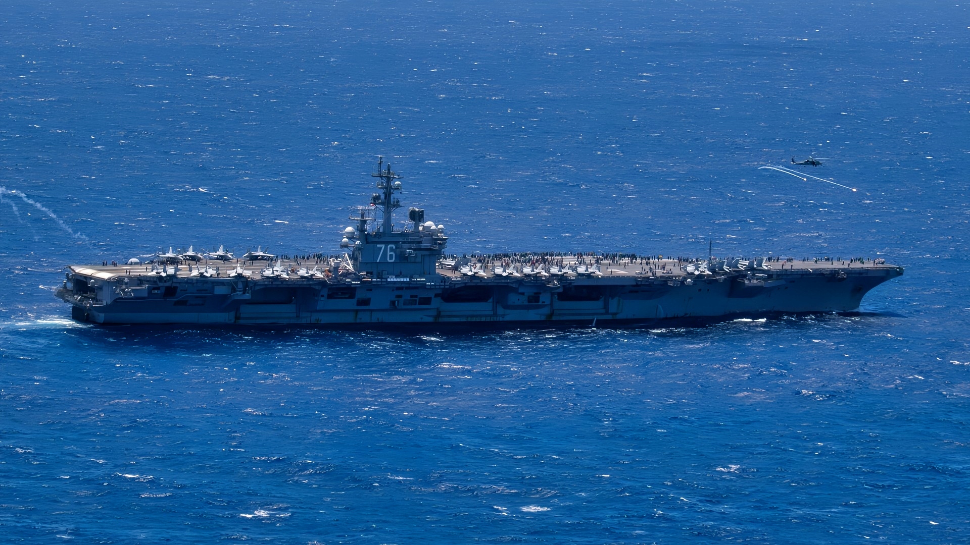 (July 3, 2024) An MH-60R Sea Hawk helicopter, attached to the Saberhawks of Helicopter Maritime Strike Squadron (HSM) 77, launches flares near the U.S. Navy’s only forward-deployed aircraft carrier, USS Ronald Reagan (CVN 76) during air combat-skills practice in the Pacific Ocean, July 3. HSM 77’s missions include surface warfare, anti-submarine warfare and a variety of support roles for Ronald Reagan and Carrier Strike Group 5. Ronald Reagan, the flagship of Carrier Strike Group 5, provides a combat-ready force that protects and defends the United States, and supports alliances, partnerships and collective maritime interests in the Indo-Pacific region. (U.S. Navy photo by Mass Communication Specialist 2nd Class Charlotte Dudenhoeffer)