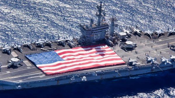 Pacific Ocean (November 3, 2003) -- During Tiger Cruise aboard USS Nimitz (CVN 68), Nimitz and Carrier Air Wing Eleven personnel participate in a flag unfurling rehearsal with the help of fellow tigers on the flight deck. The Nimitz Carrier Strike Force and Carrier Air Wing Eleven (CVW-11) are in route to Nimitz homeport of San Diego, California after an eight-month deployment to the Arabian Gulf in support of Operation Iraqi Freedom. U.S. Navy photo by Photographer Mate 3rd Class Elizabeth Thompson