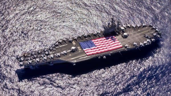 Pacific Ocean (November 3, 2003) -- During Tiger Cruise aboard USS Nimitz (CVN 68), Nimitz and Carrier Air Wing Eleven personnel participate in a flag unfurling rehearsal with the help of fellow tigers on the flight deck. The Nimitz Carrier Strike Force and Carrier Air Wing Eleven (CVW-11) are in route to Nimitz homeport of San Diego, California after an eight-month deployment to the Arabian Gulf in support of Operation Iraqi Freedom. U.S. Navy photo.
